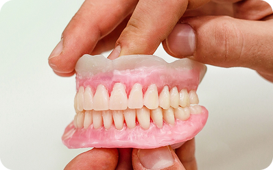 Full dentures held in a technician's hands
