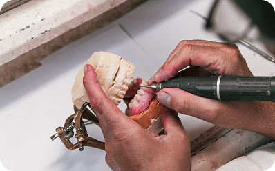 Denture being repaired with a rotary tool